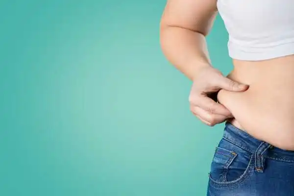 Image of woman pinching her love handles to show weight gain Sutton Coldfield
